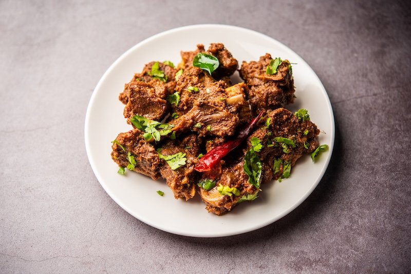 Sukha mutton or chicken, dry spicy Murgh or goat meat served in a plate or bowl